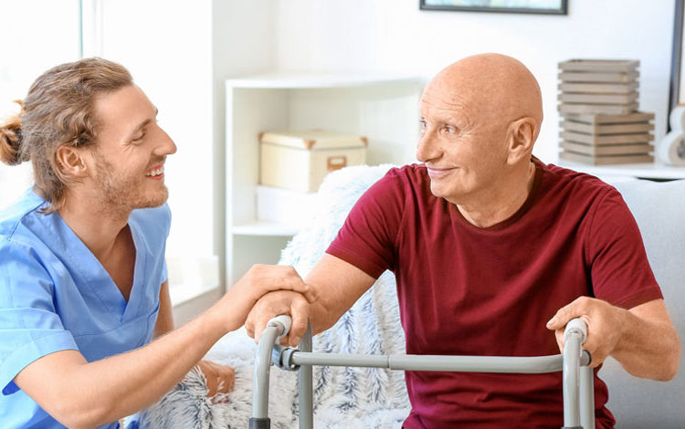Elderly-Man-With-Caregiver-In-Nursing-Home